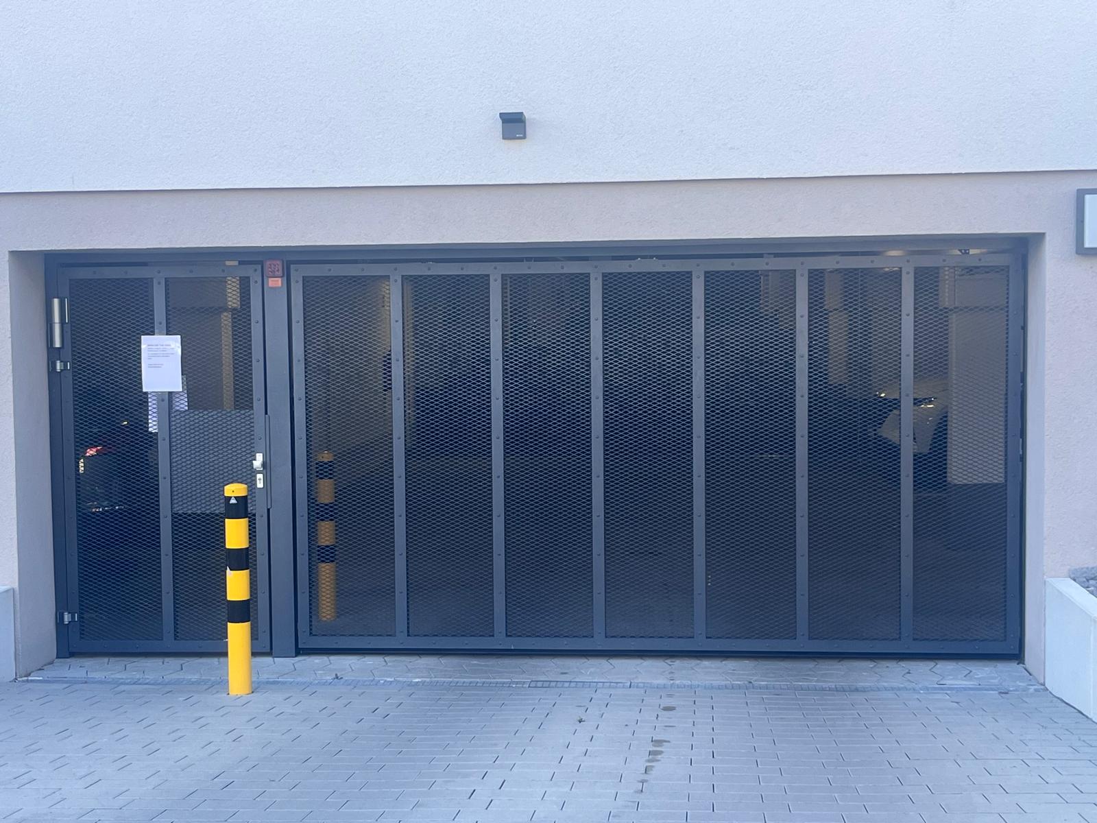 Verglastes Falttor an einer Garageneinfahrt